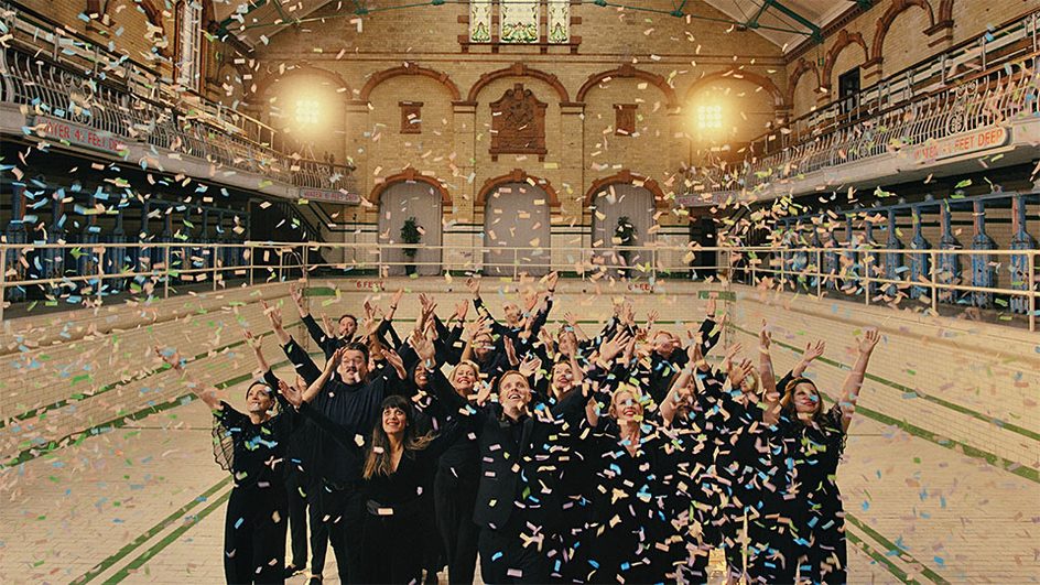 Eno members , hands in air in a shower of confetti